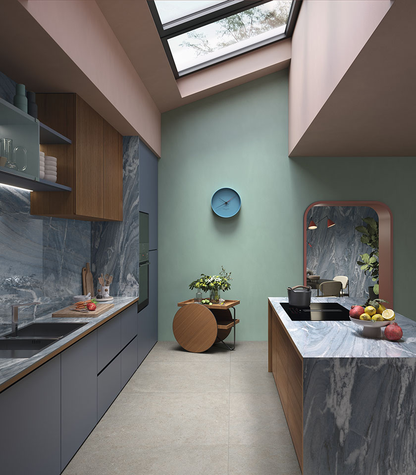 Contemporary kitchen with wood cabinetry and blue-grey surfaces, featuring flooring from the Intense collection with a Crete stone effect and coverings from the Noblesse collection with a Blue River marble effect.