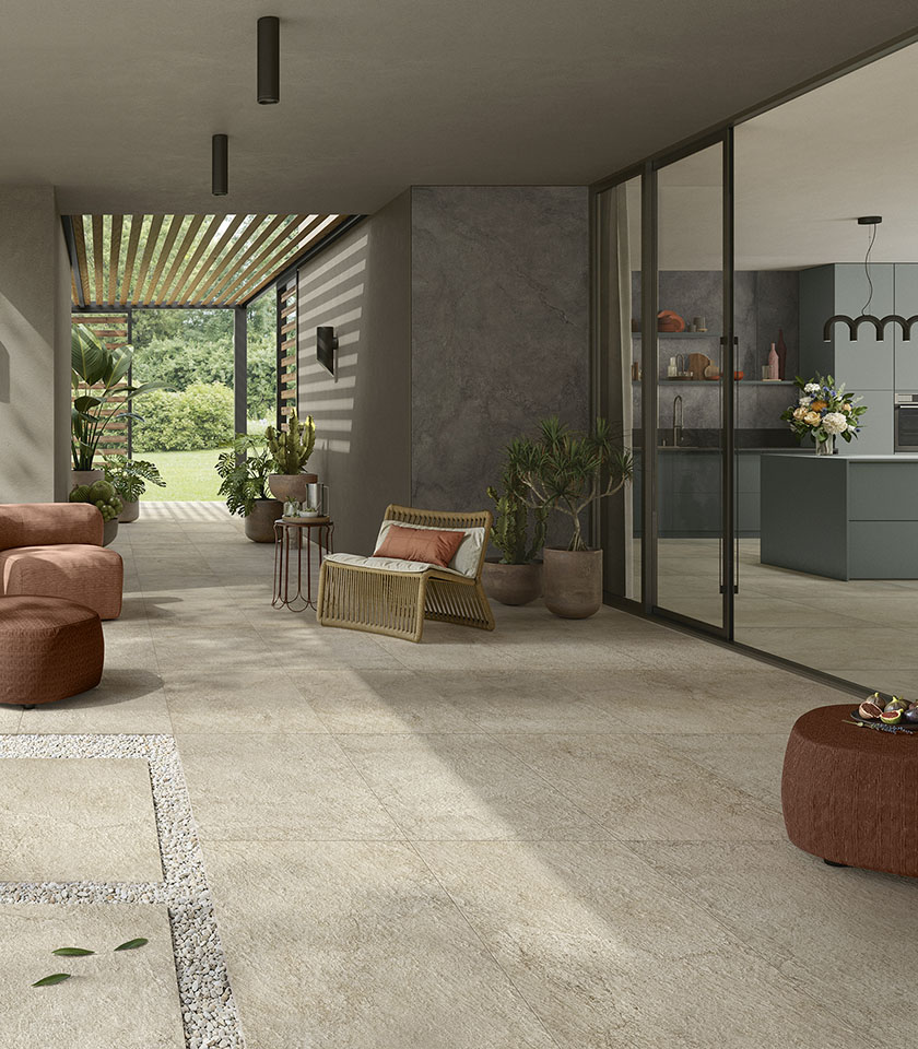 Contemporary indoor-outdoor living space with flooring from the Pulse collection in Sand Rough stone effect and wall coverings in the Shadow shade.