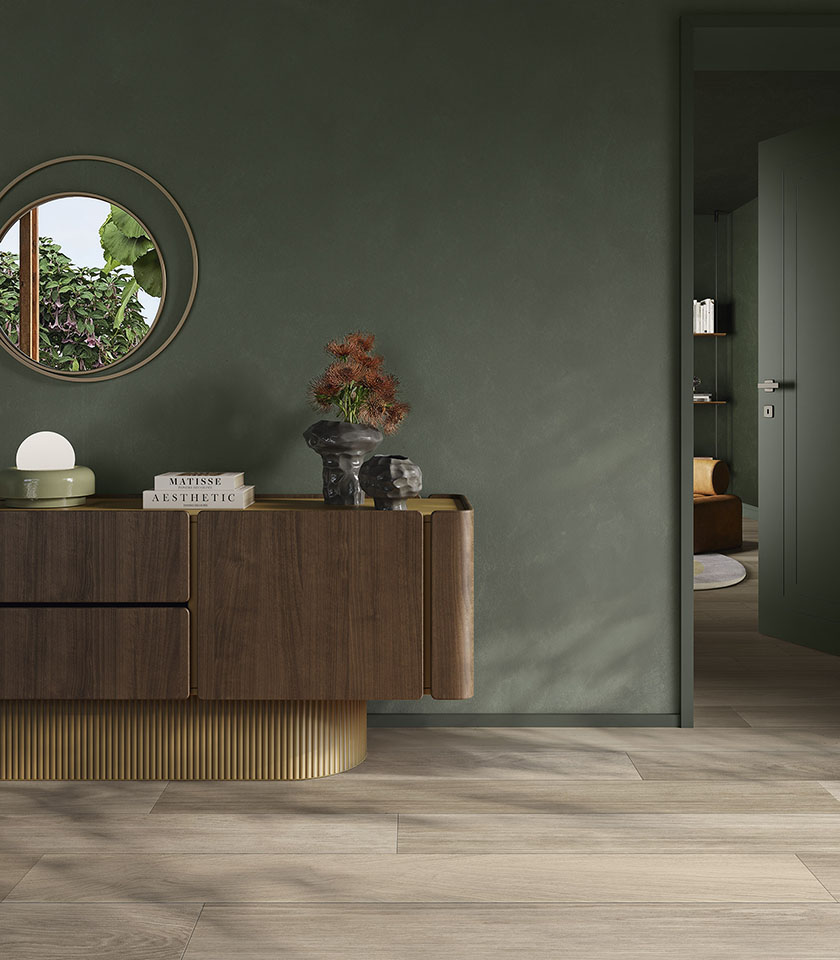 Contemporary interior with Biocharme Havana wood-effect flooring, sage green walls and elegant wooden furnishings.