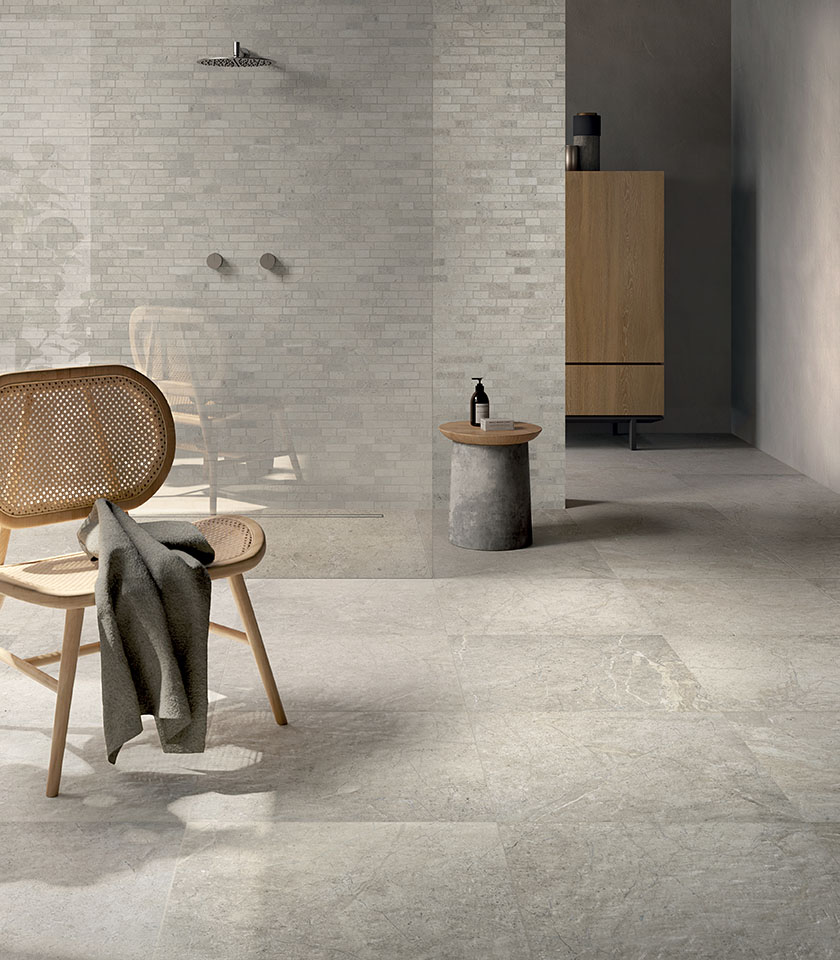 Minimal chic bathroom with light stone-effect flooring, tone-on-tone textured wall covering, walk-in shower and essential wooden furnishings.