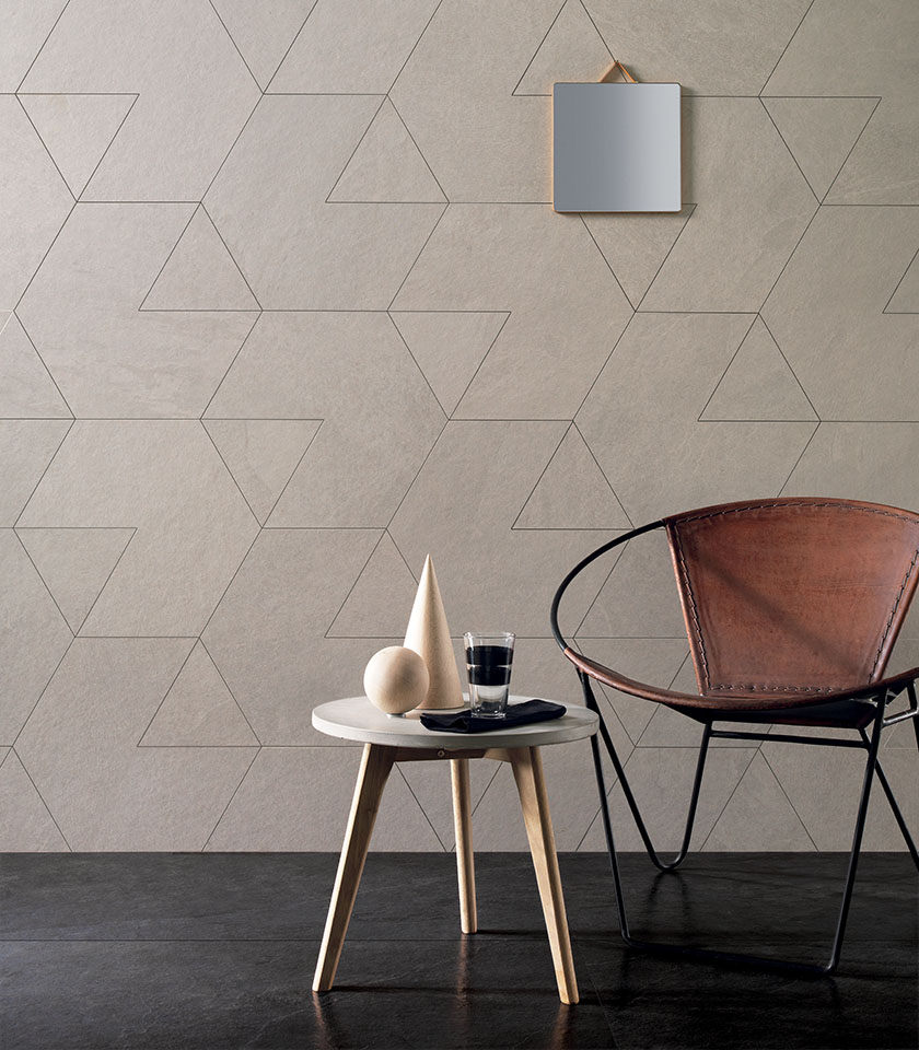 Japandi-style living room with geometric stone-effect wall tiles, leather armchair and minimalist side table.